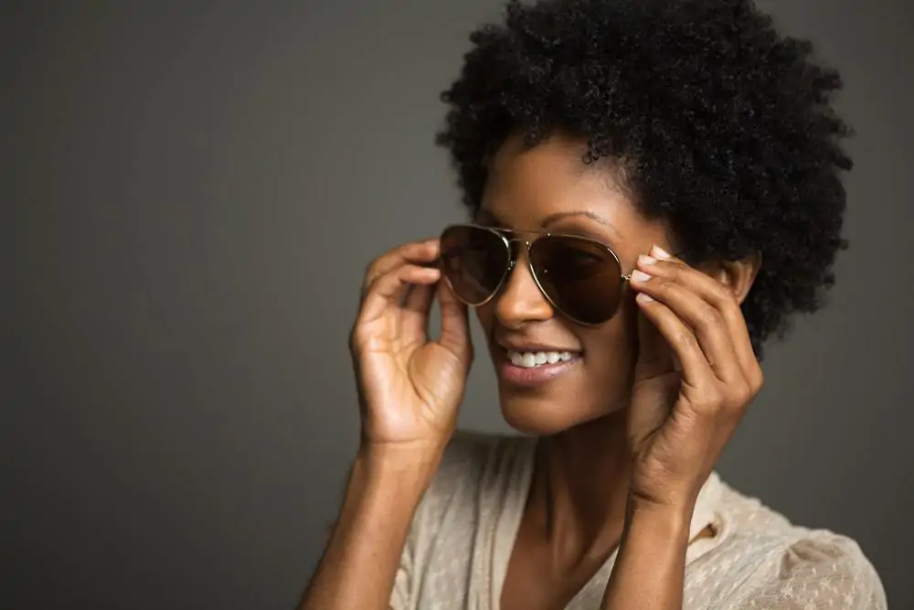 A black female with kinky curls styled with coconut oil for stimulating hair growth (and for hair loss treatments)