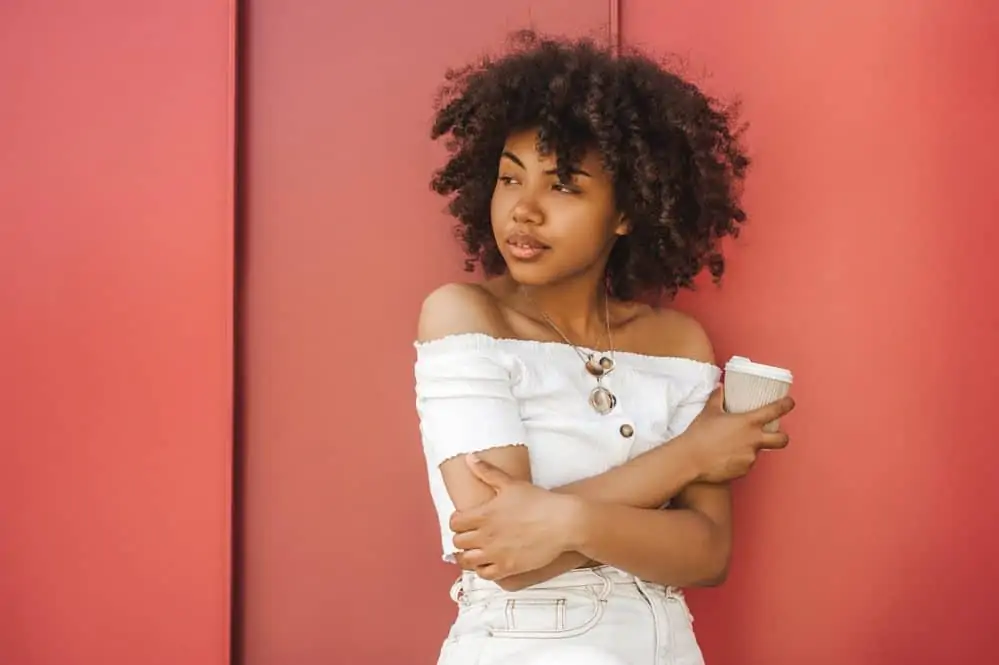 Light-skinned black female wearing flexi-rod curls with styling cream after drying her freshly washed wet hair.