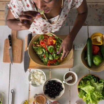 This young African American female is making a salad, which is a great food for hair growth and thickness.