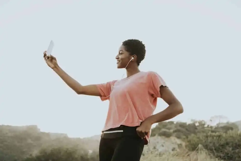 Young attractive African American with hair that's barely an inch long taking a selfie after getting her hair curled.