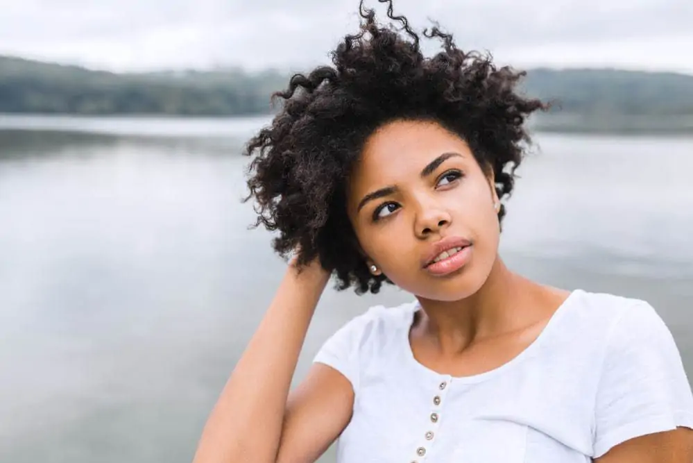 Pretty young black women wondering about the risks of using baking soda to clean her 4A curls