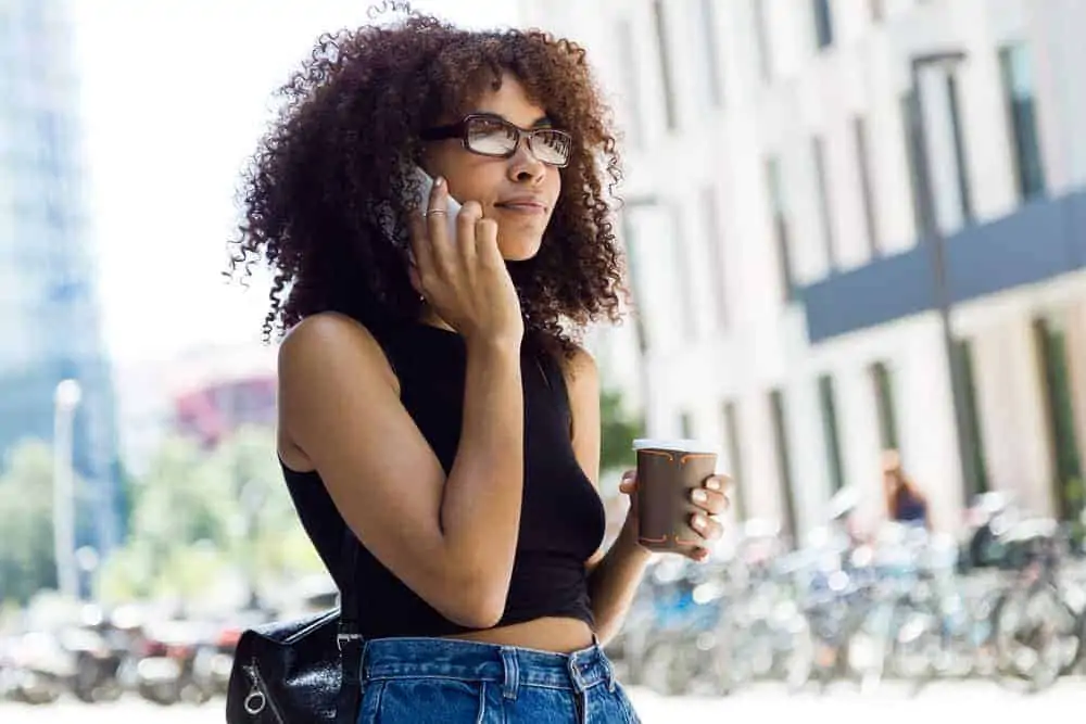 A young American woman wearing a two-strand twist-out hairstyle colored with Manic Panic Purple Haze hair dye.