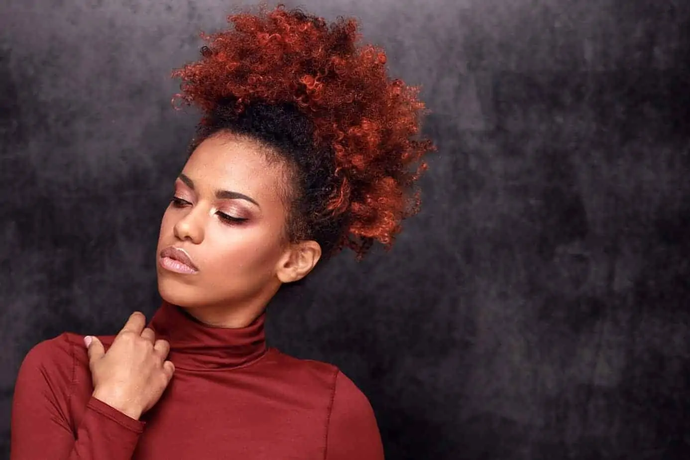 Black women with curly hair side-eyeing someone on her right, not looking directly into the camera. 