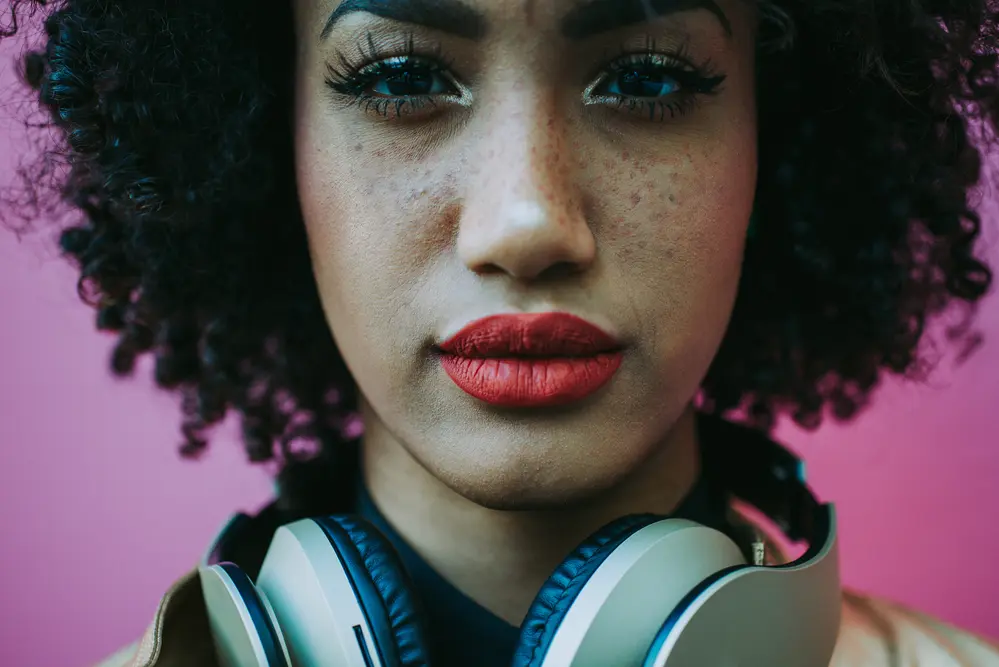 Latin woman with curly hair that been treated with cedarwood oil starring directly into the camera.