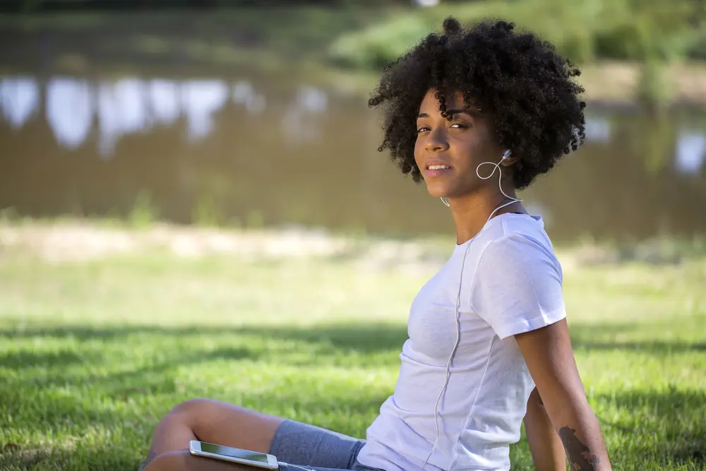 Portrait of a young african american woman listening to music on cell phone