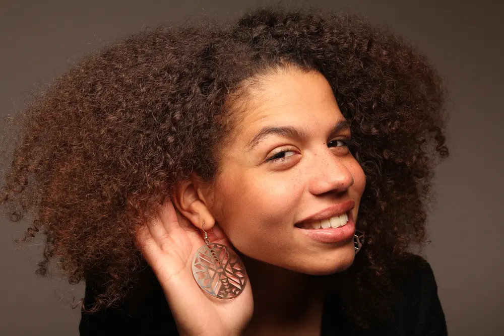 American women with big gold earrings with an African symbol.