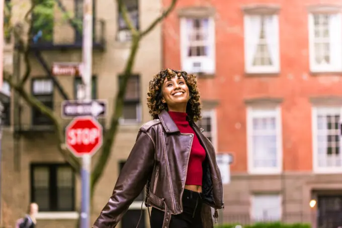 Female standing outside in the city street   dancing and smiling