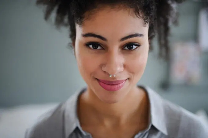 Black women wearing a nose ring, pink lipstick, and pineapple hairstyle