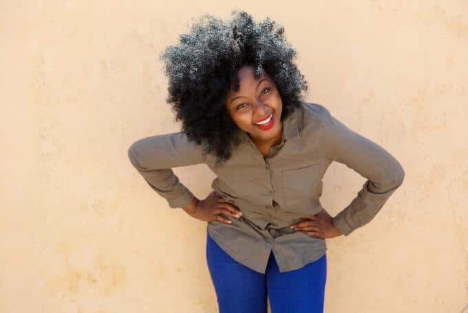 Happy black girl with light brown skin wearing red lipstick and cool eye cream