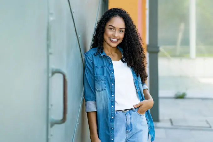 African American women wearing a blue jean outfit and a white t-shirt with type 3c natural hair. 