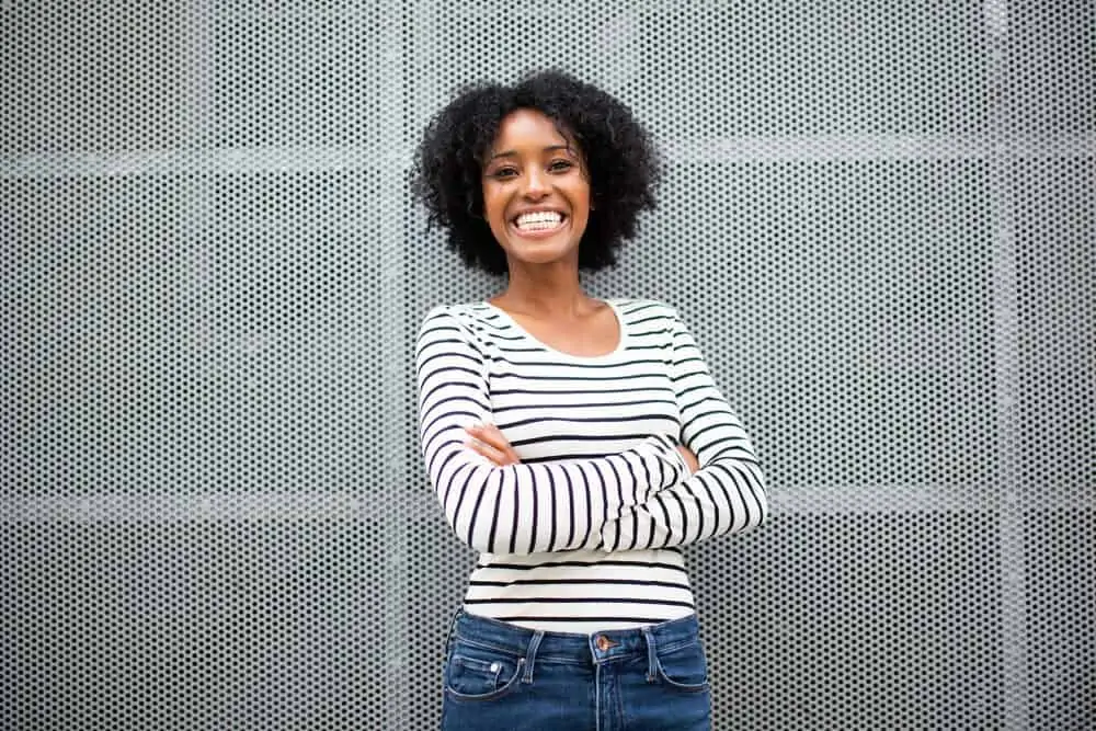 Cute women standing outside wearing a black and white long sleeve shirt and casual jeans.