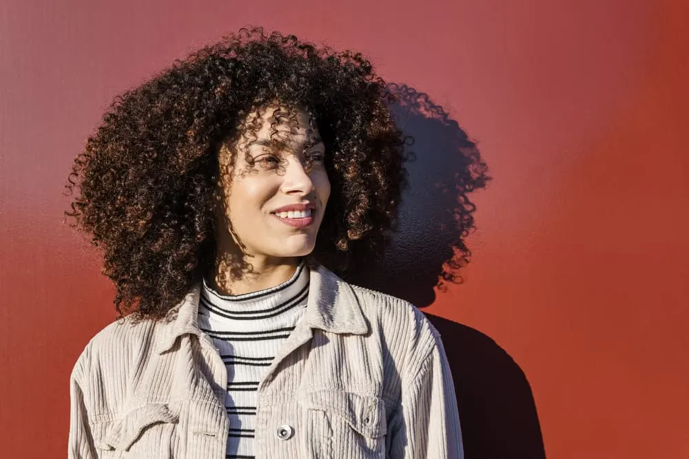 African American female with a big smile rocking a type 3a curly afro hairstyle.