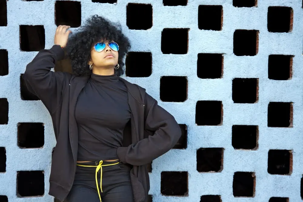 Mixed-race women wearing an all-black outfit and a multi-colored bracelet.