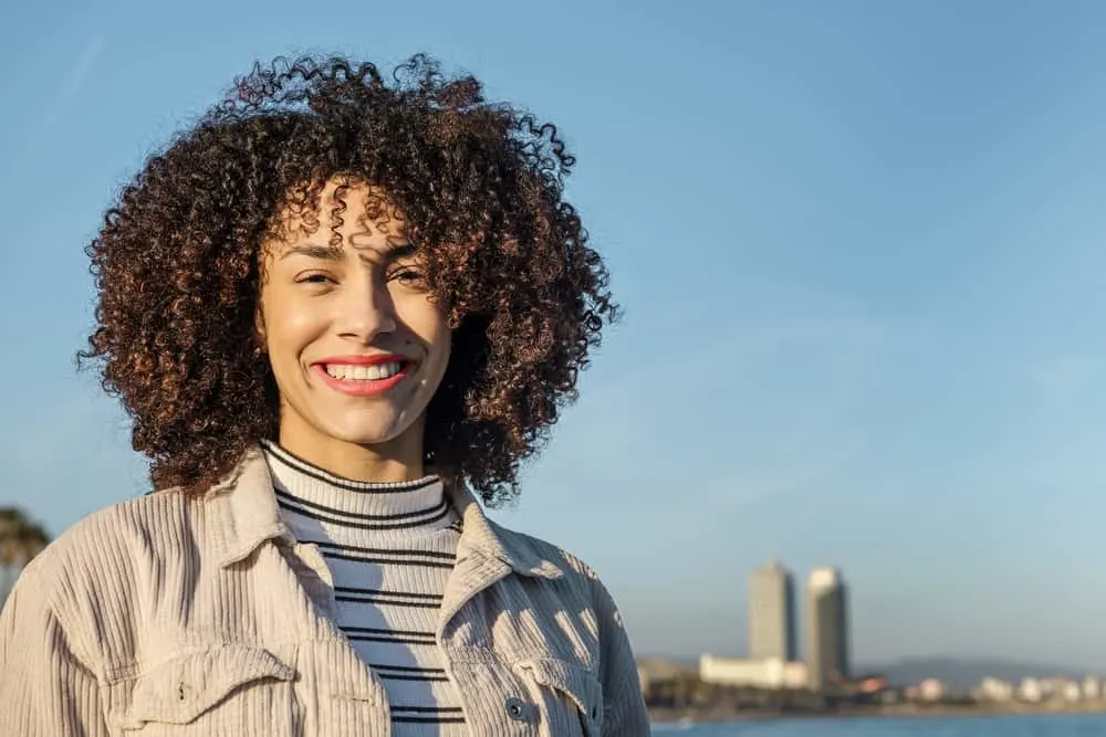 Beautiful African American female with natural hair standing in front of a New York City skyline.