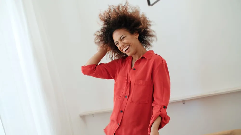 Black female ready to leave the house after a shower wearing a red dress shirt