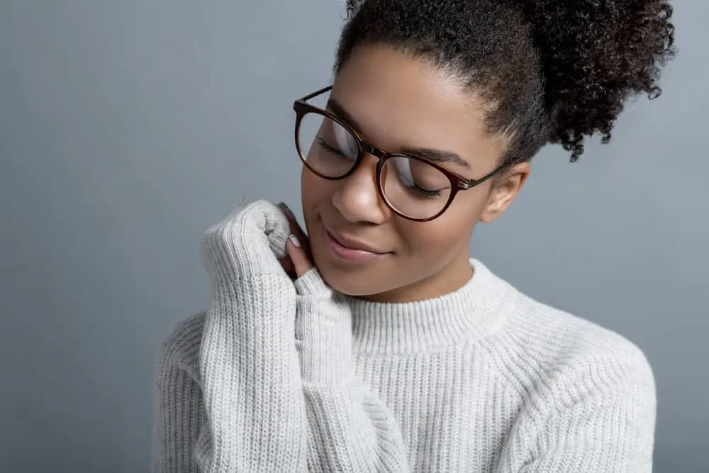 Lady wearing a gray sweater avoiding eye contact as the woman touches her chin.