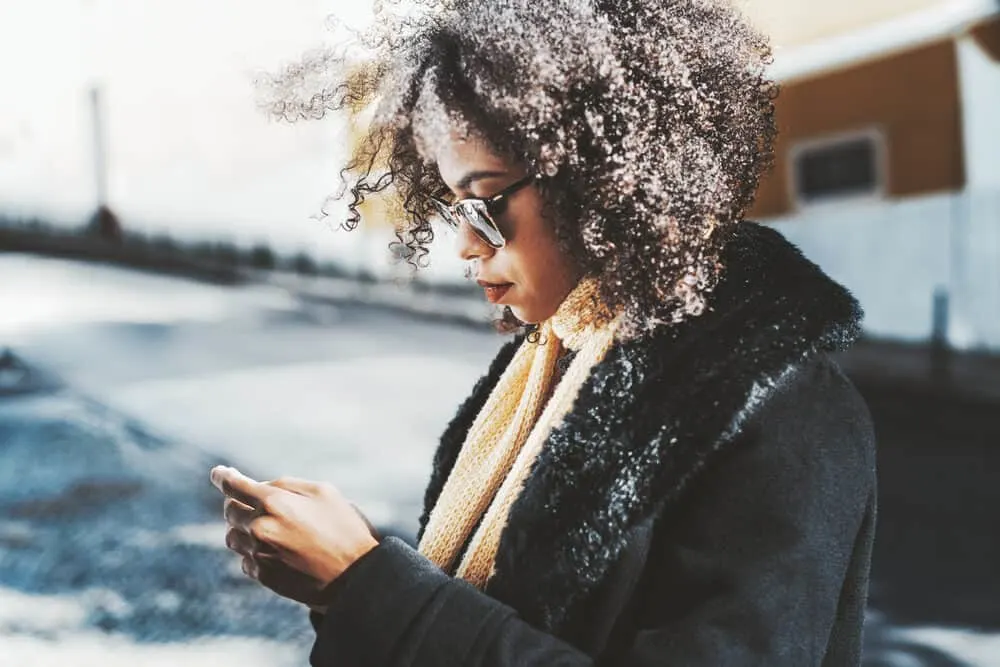 A black girl researching micro-link hair extensions and the hair extension method combined them with real human hair.