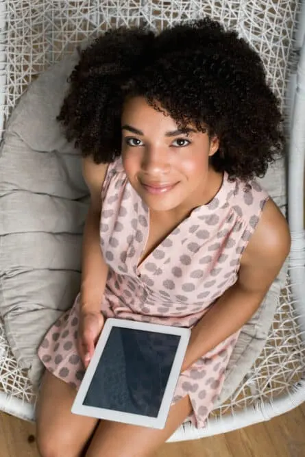 Women playing with an iPad while showing physical signs of being interested in the conversation.