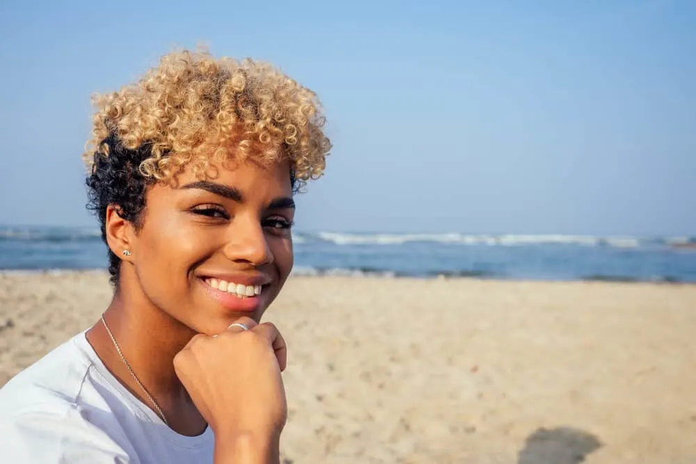 Young Latin female with black and blonde colored hair posing for a photo at the beach