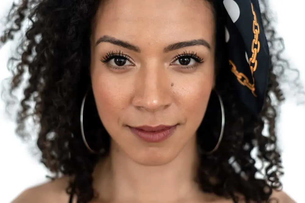 Close-up photo of a young black girl with silver earrings and a headscarf