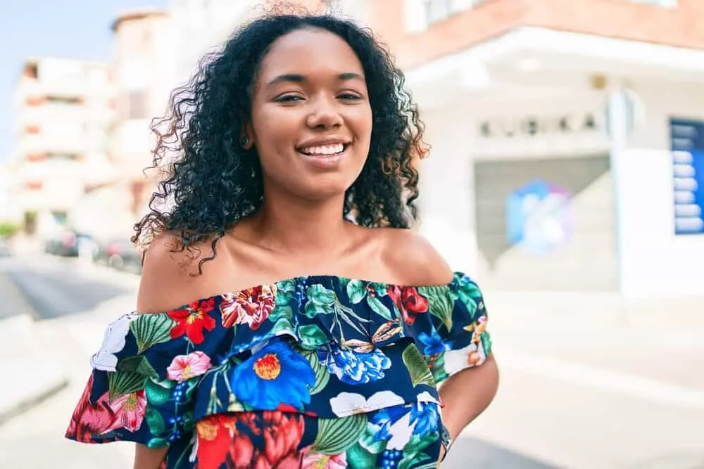 African American female with curly visible head hair and without any facial hair