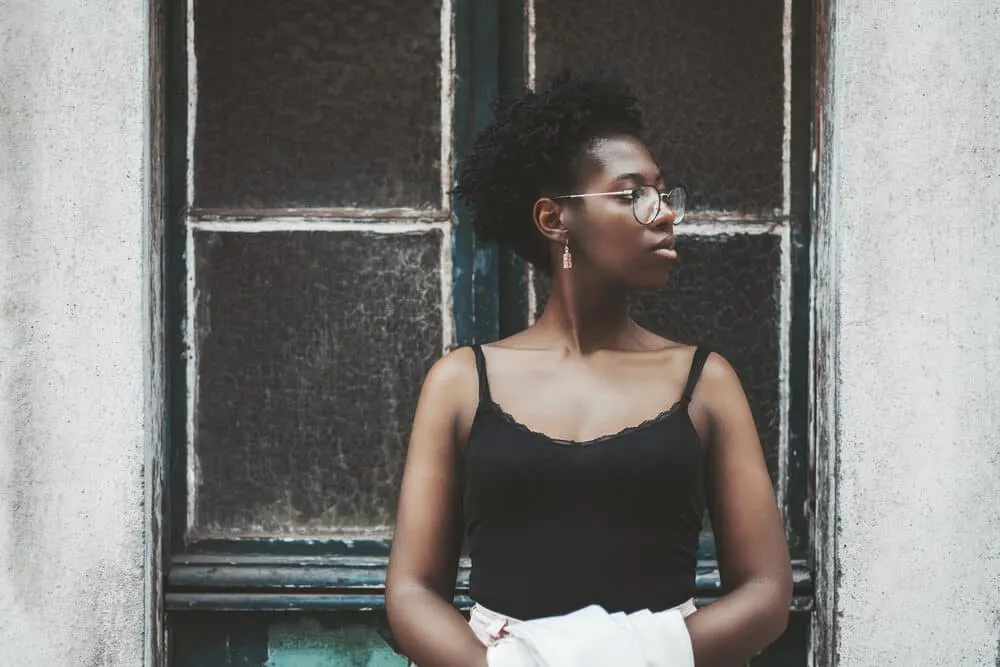 Charming young female standing outside with 4D flat-shaped locs with a tight curl pattern