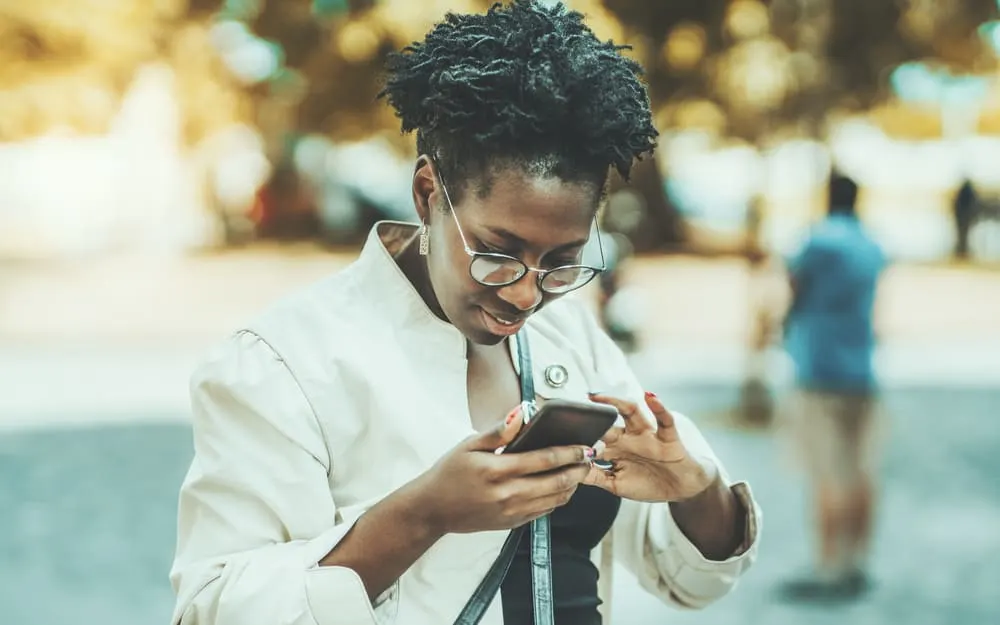 Cute African American wearing eyeglasses with starter micro locs on 4D natural hair.