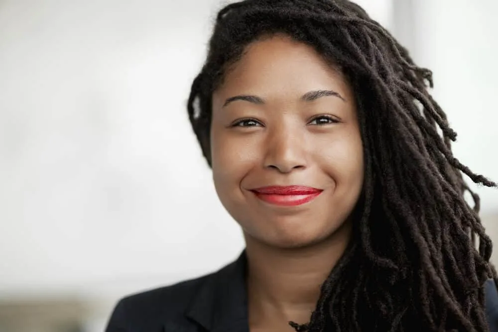 Cute black girl with sister locs started by palm rolling her comb coils