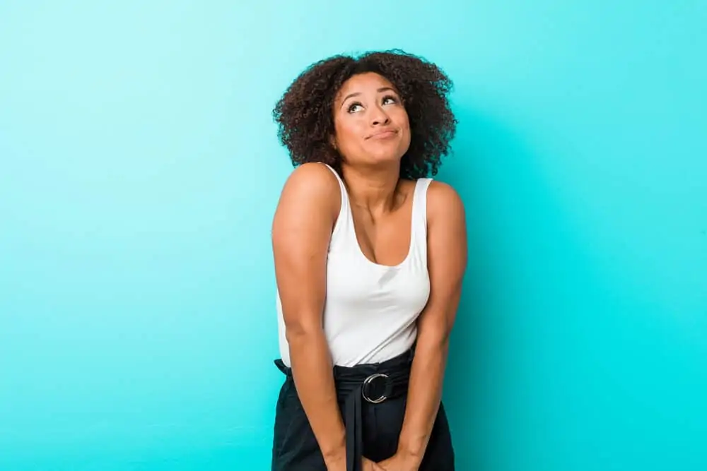 Cute black girl with passion twist hair extensions wearing a white t-shirt and blue pants