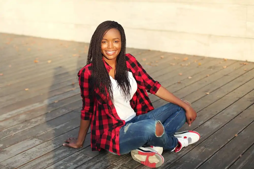 Beautiful young African American female sitting outside on a summer day wearing faux locs after a hot oil treatment