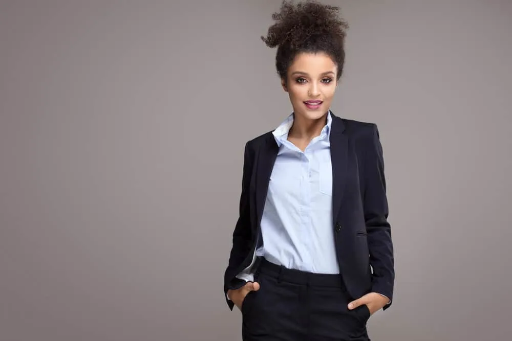 African American female with medium length hair wearing a blue suit with a neat and classic finish