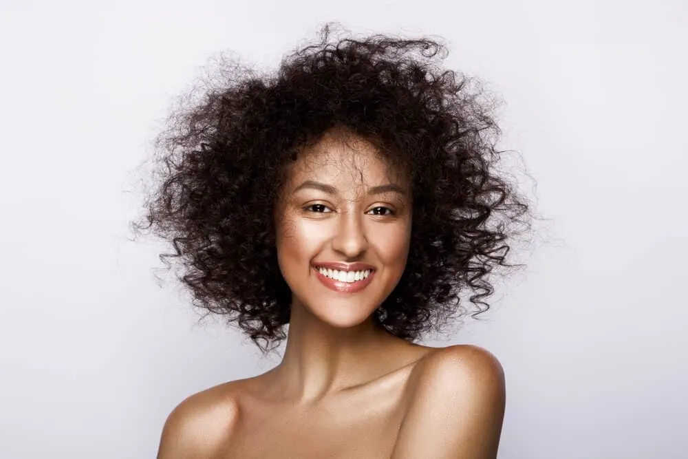 Cute African American female with type 3 curly hair strands 