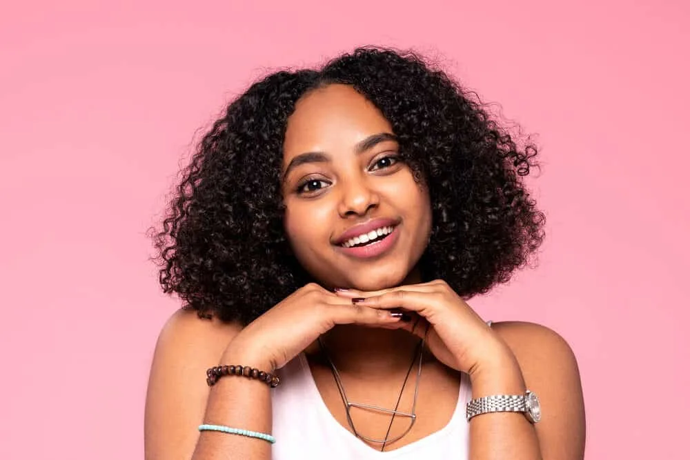 Smiling happy African-American woman wearing a silver watch and a brown and black bracelet