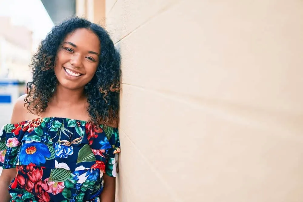 A beautiful black woman that's a physical beauty with longer hair than most curly girls