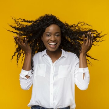 Cute black girl playing in her wavy hair