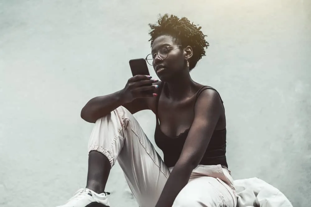 Young African girl with nail-art and a short hair length wearing starter sister locs and casual clothes