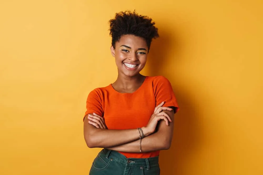 Female with curly dry hair smiling after washing her hair with a silicone-free shampoo