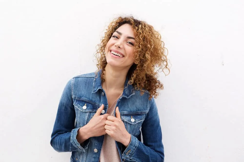 Young Caucasian lady wearing a denim jacket after using a Wella hair toner on brassy hair