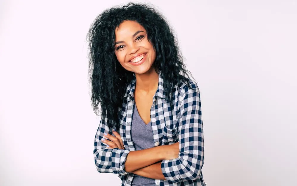 Black girl wearing a blue and white checkerboard shirt with human hair extensions