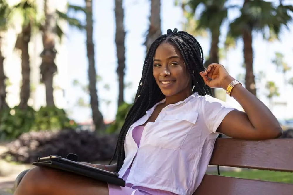 Nice lady stopped on a park bench with braided dreadlocks that can be easily undone