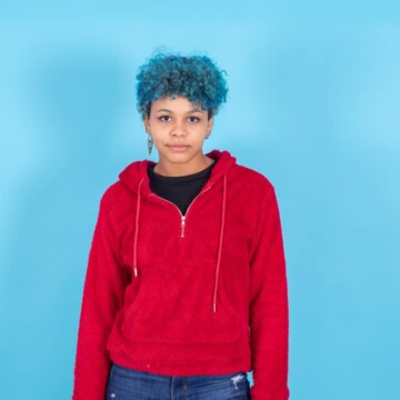 Trendy African American woman with a deep blue shade semi-permanent hair dye on curly hair