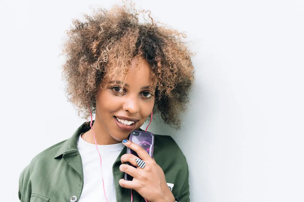 African American female wearing a curly twist-out created by styling hair with natural oils and hair dryer for volume.