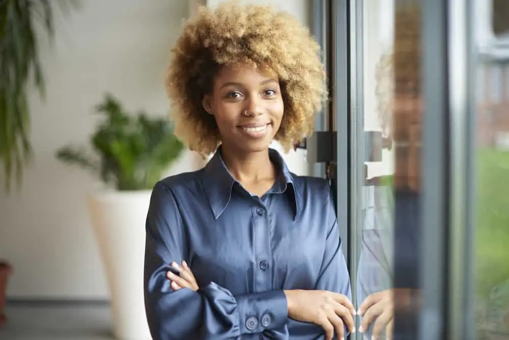 Cute African American female with blonde healthy hair without any signs of bleaching damage or split-ends.