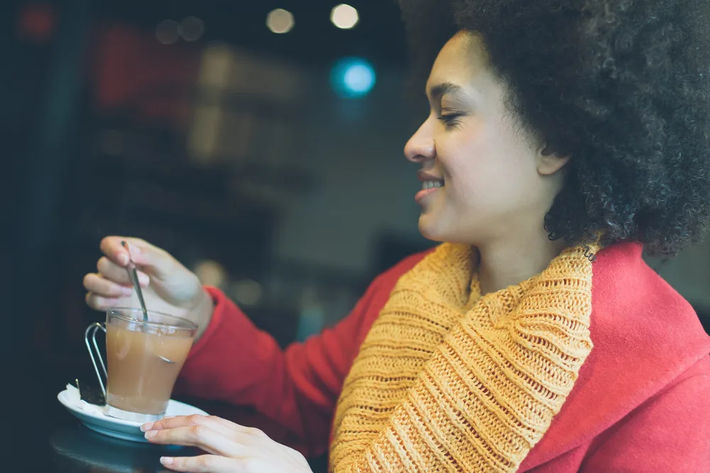 Beautiful young woman drinking hot tea sweetened with powdered sugar and corn syrup.