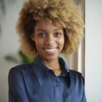 African American female with natural black hair that's been bleached creating a blonde hair shade.