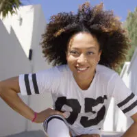 Cute African American female with a black natural hair color that's been dyed on the tips with brown hair dye.