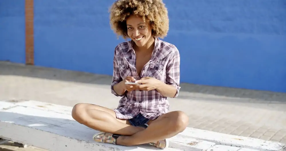 Young female sitting with her legs crossed in front of the beach.