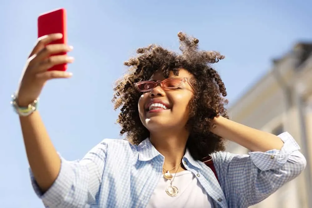 Upbeat woman with light brown hair with red tones in the sunlight.