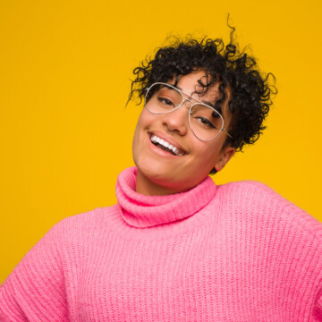 A cute African American woman wearing black Ion hair dye to enhance her natural color.