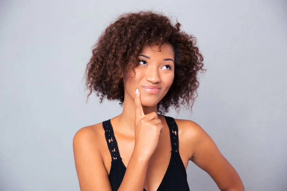 Black girl with curly dry hair that hasn't done a good job moisturizing her curls.